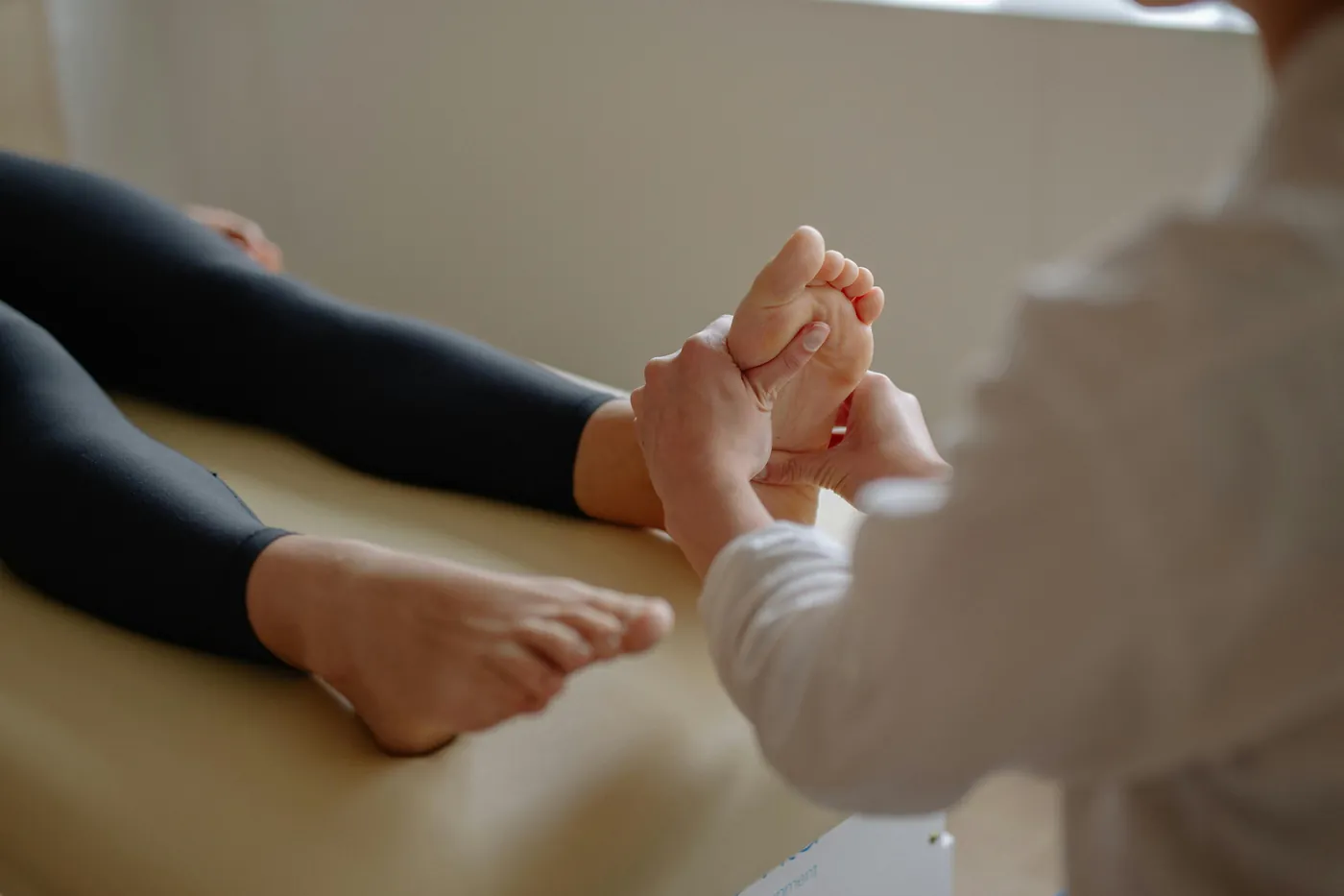 Reflexologist giving a mobile reflexology treatment in a client's living room