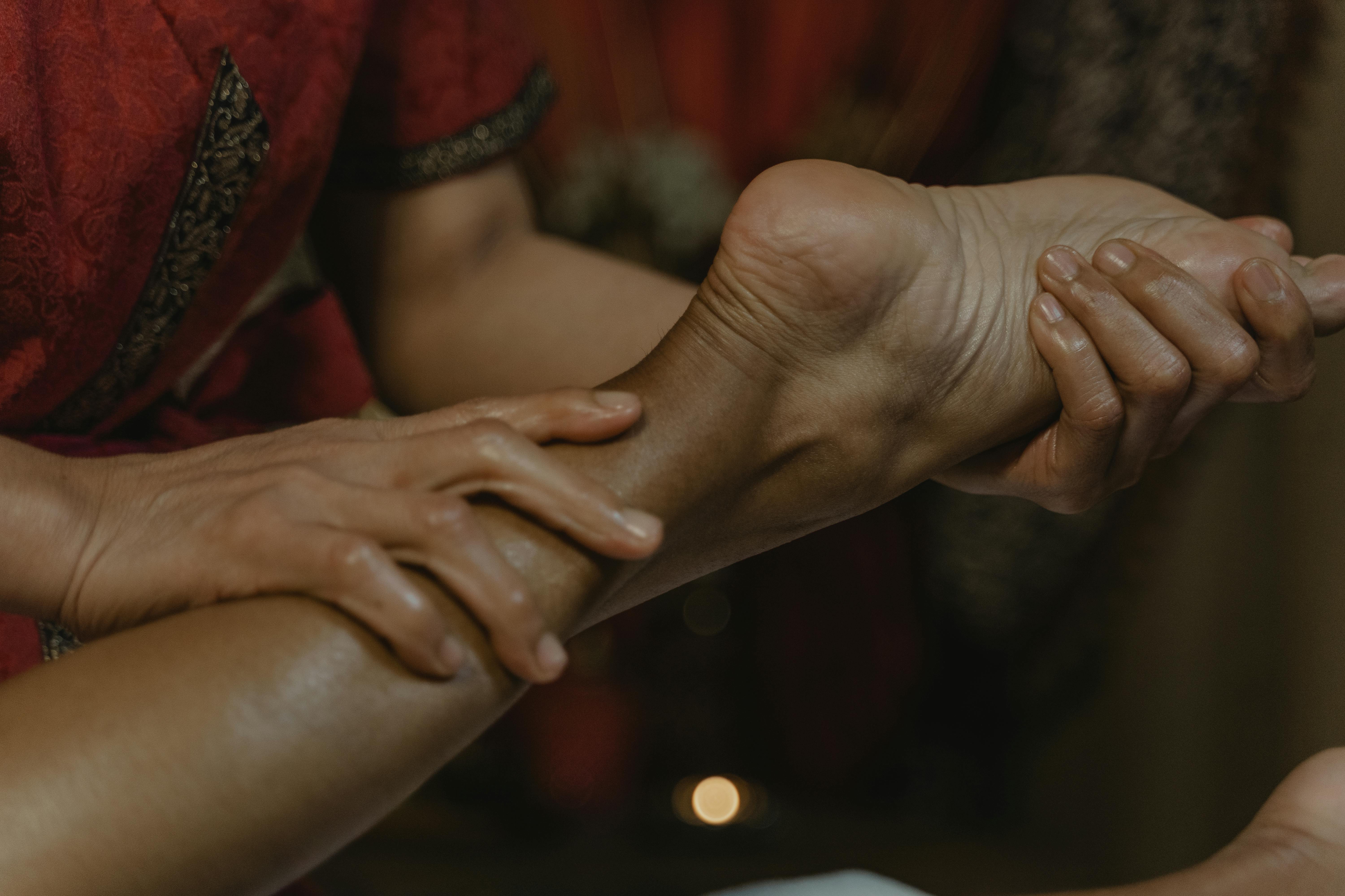 Reflexologist gently working on a client's foot during a calming treatment for stress relief